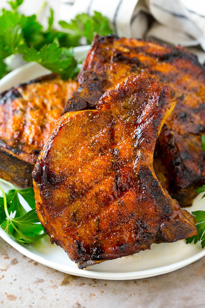 Un plato de chuletas de cerdo ahumadas aderezado con perejil fresco.