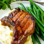 Costillas de cerdo ahumadas sobre puré de patatas con judías verdes.