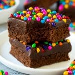 Una pila de brownies cósmicos en un plato con algo para comer.