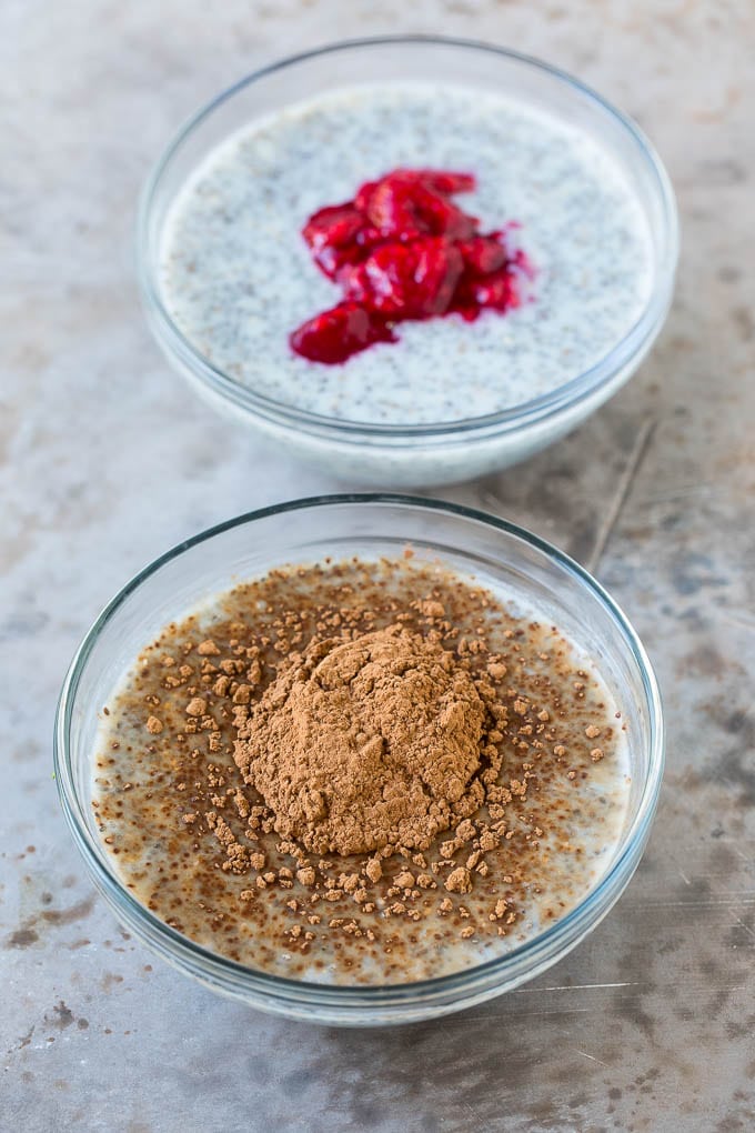 Tazones de pudín de chía, uno con cacao en polvo y otro con frambuesas picadas.