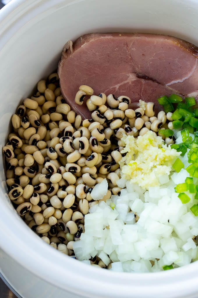Ingredientes para guisantes de ojo negro con jamón en la olla de cocción lenta.