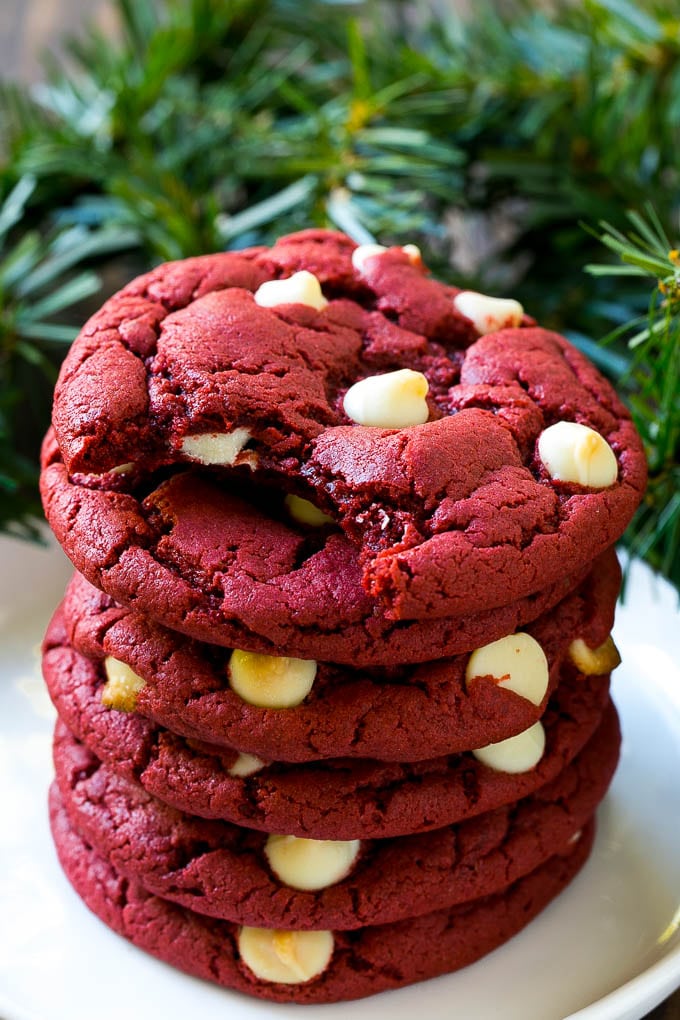 Receta de galletas de terciopelo rojo | Galletas de chocolate blanco de terciopelo rojo | Galletas Red Velvet Cake Mix #redvelvet #cookies #whitechocolate #christmas #dinneratthezoo Una pila de galletas de terciopelo rojo en un plato.