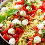 Caprese con tomate fresco picado, bocados de mozzarella y albahaca picada.