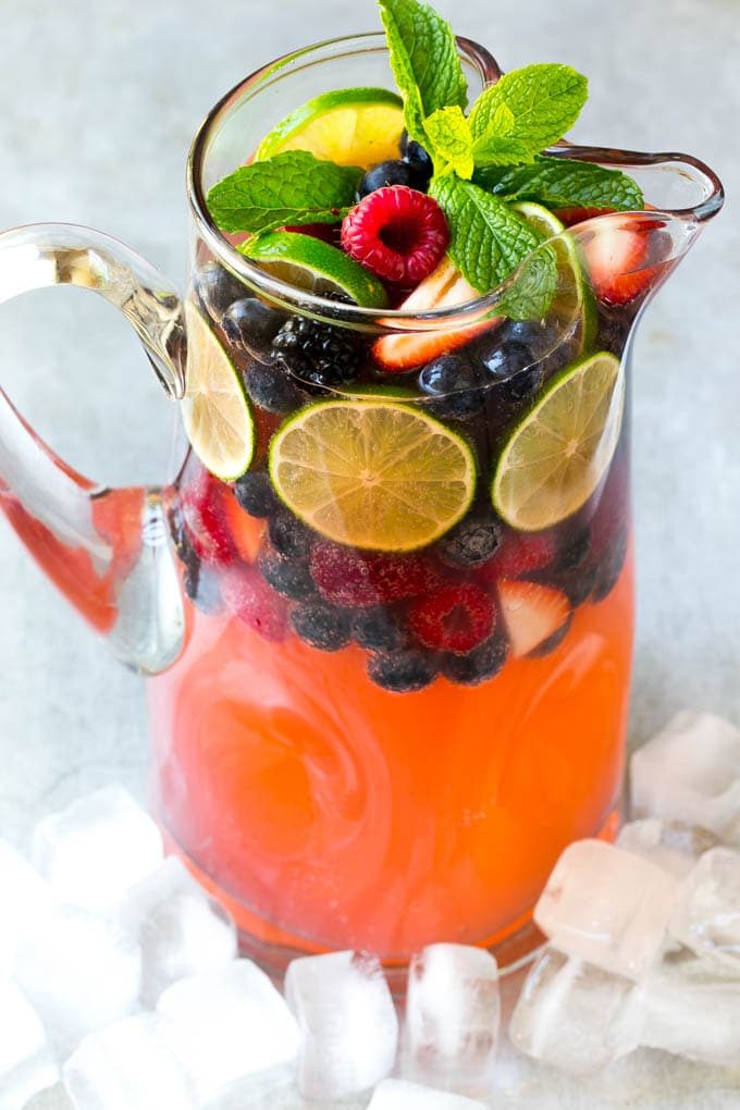 Flauta de ponche de champán adornado con frutos rojos y menta.