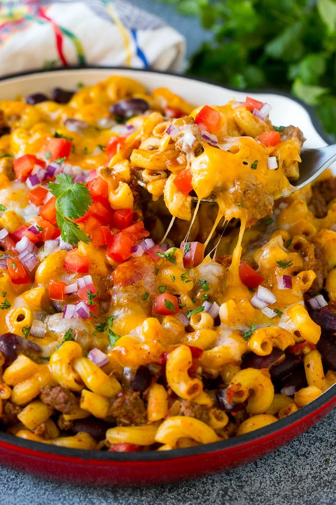 Una cuchara para servir en una olla de chili mac, recogiendo una porción.
