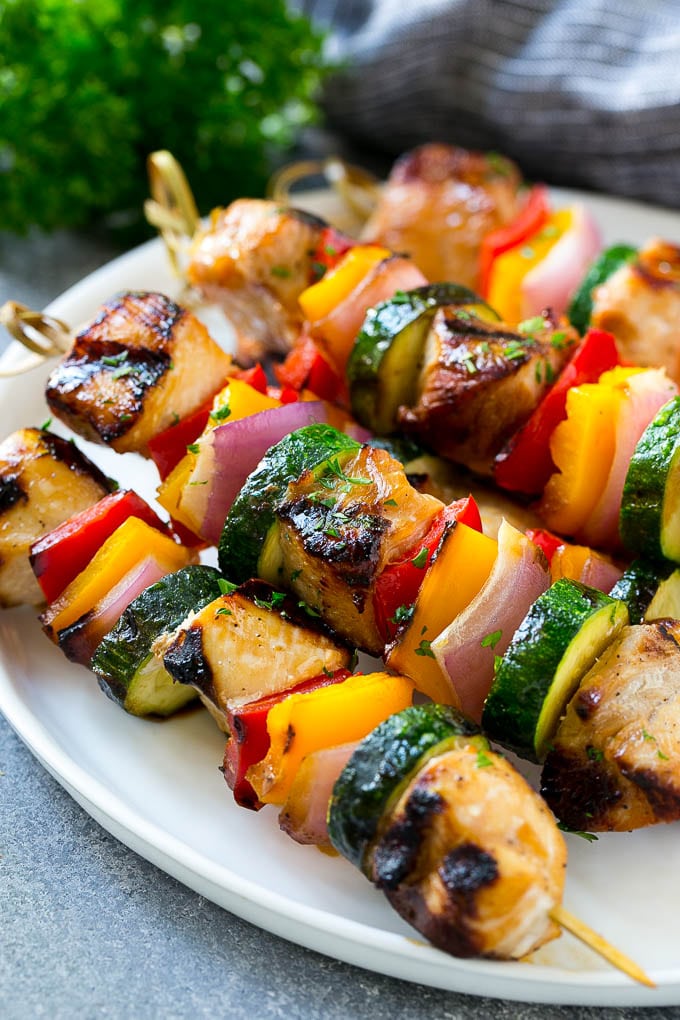 Receta de brochetas de pollo a la parrilla |  Brochetas de pollo y verduras |  Brochetas de pollo a la parrilla # grill #pollo #kabobs #dinner #dinneratthezoo Un plato de brochetas de pollo a la plancha elaboradas con pollo adobado y verduras de colores.
