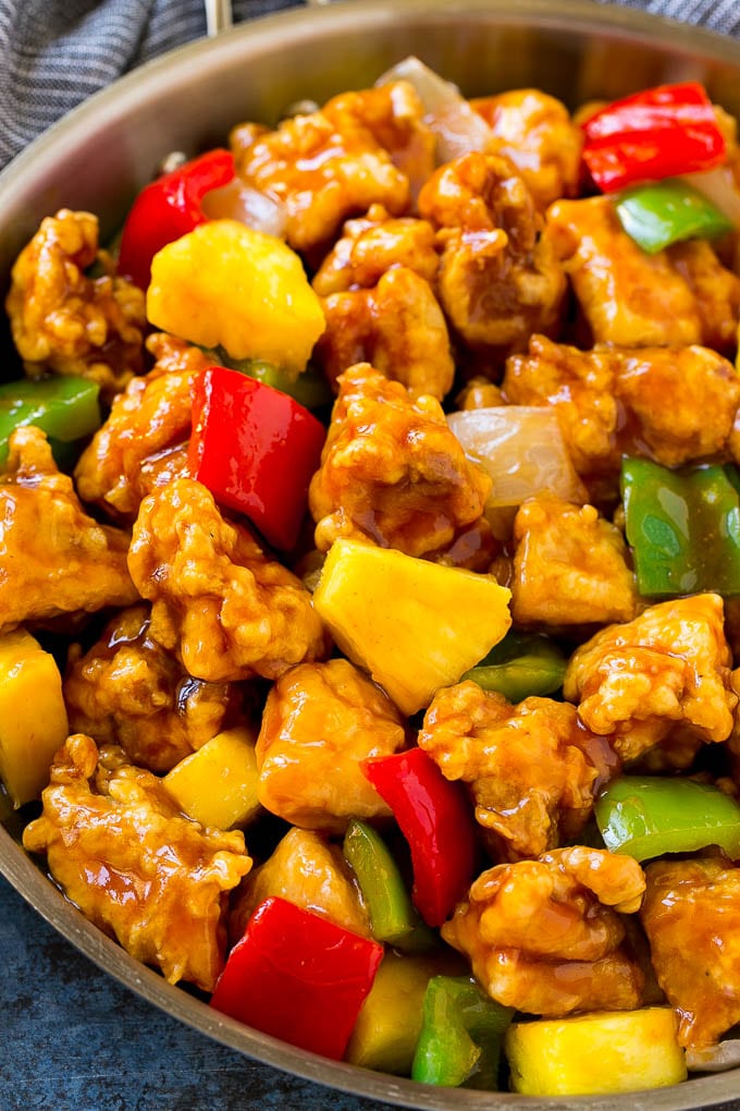Receta de pollo agridulce |  Receta de copia de comida china |  Pollo con piña #comida china #ananas #stirfry #takeout #dinner #dinneratthezoo Una sartén de pollo agridulce con pollo crujiente, piña, pimientos y cebollas.