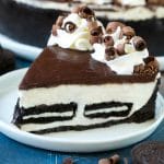Una rebanada de pastel de queso Oreo sin hornear con corteza de galleta, relleno de pastel de queso y Oreo y relleno de chocolate.