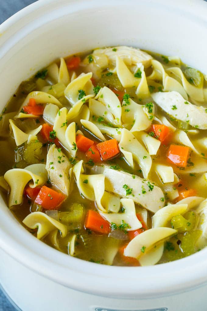 Sopa de pollo con fideos y verduras en olla de cocción lenta.