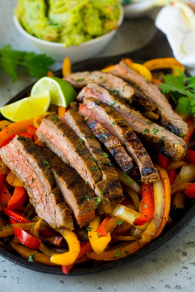 Una sartén de fajitas de bistec con pimientos rojos y amarillos.
