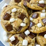 Un plato de galletas S'mores adornado con barras de chocolate con leche y malvaviscos.